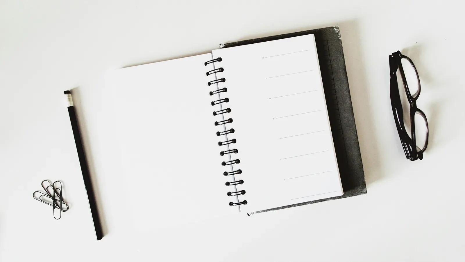 Aufgeschlagenes Notizbuch mit Stift auf einem hellen Tisch